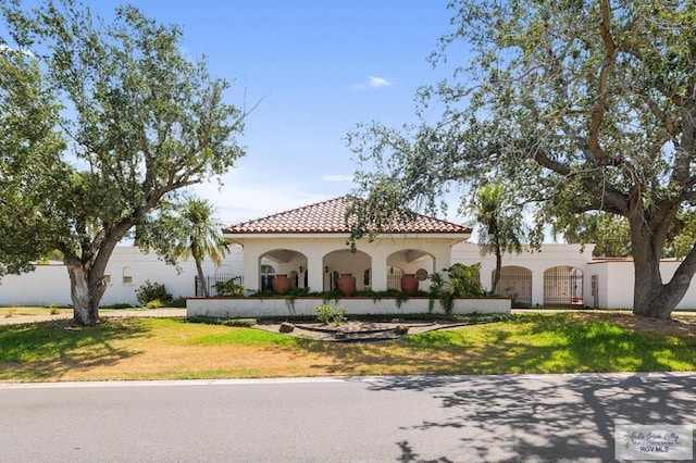 mediterranean / spanish home featuring a front lawn