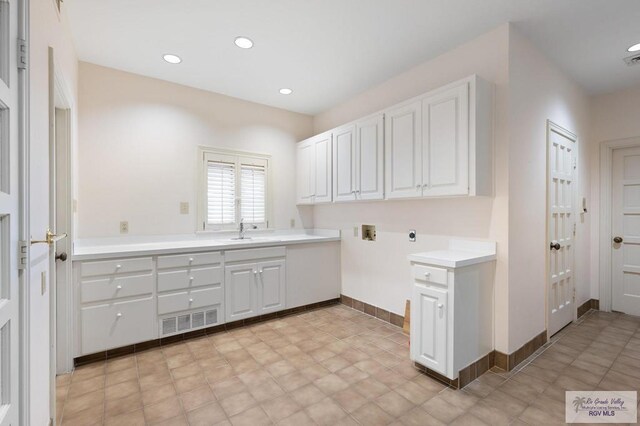 clothes washing area featuring sink, hookup for a washing machine, cabinets, and hookup for an electric dryer