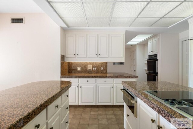 kitchen with white cabinets, white electric cooktop, and tasteful backsplash