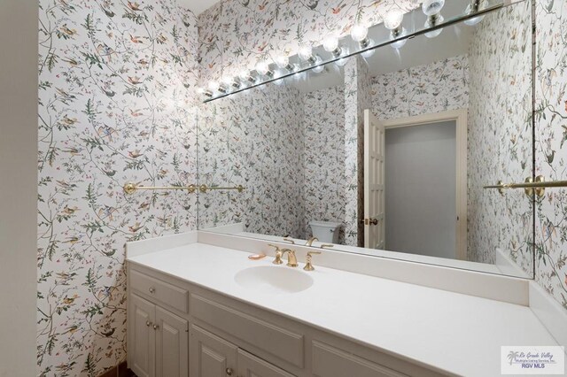 1700 Tesoro Ave, Rancho Viejo, TX 78575 - half bath with wallpapered walls, vanity, and toilet