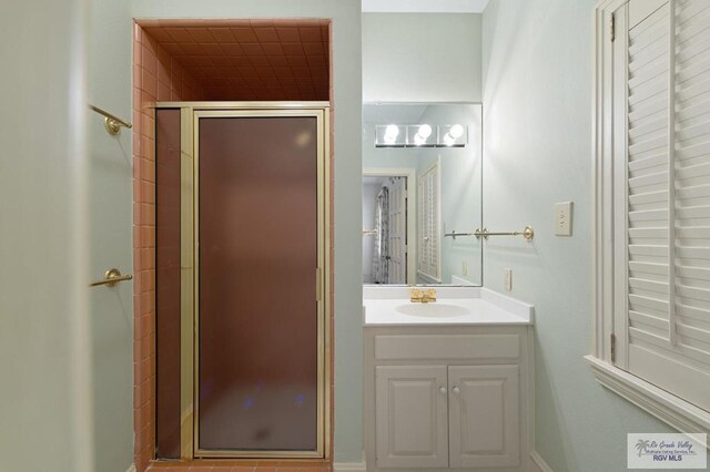 bathroom with a shower with door and vanity