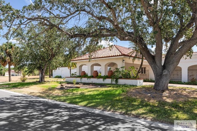 mediterranean / spanish home featuring a front lawn