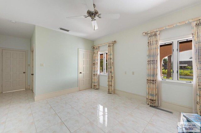 tiled spare room with ceiling fan