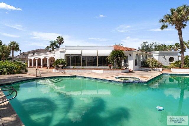 view of swimming pool featuring an in ground hot tub and a patio