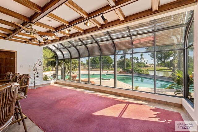 unfurnished sunroom featuring beam ceiling, ceiling fan, and coffered ceiling