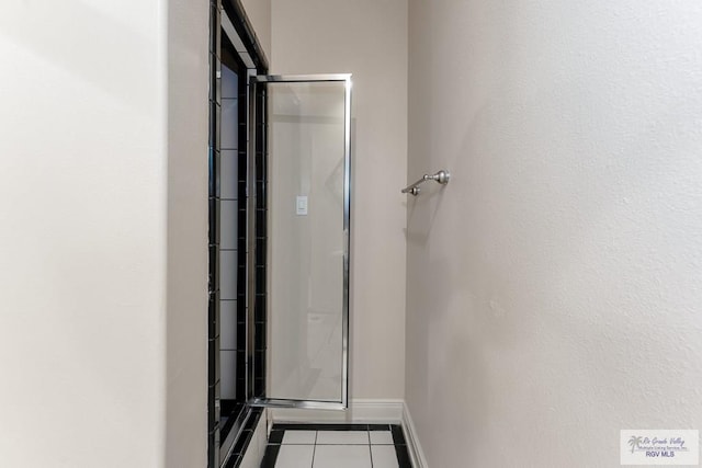 bathroom with tile patterned floors and a shower with door