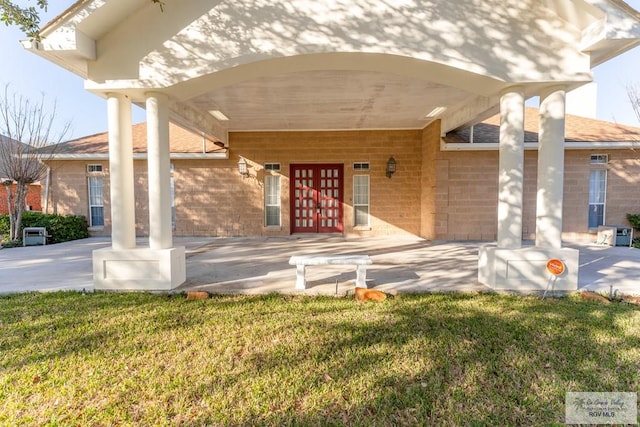 entrance to property with a yard and french doors