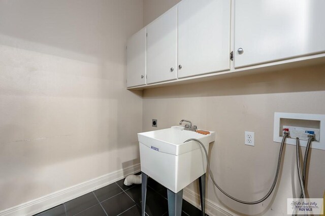 405 E Matz Ave, Harlingen, TX 78550 - laundry area featuring cabinet space, hookup for a washing machine, electric dryer hookup, baseboards, and dark tile patterned flooring