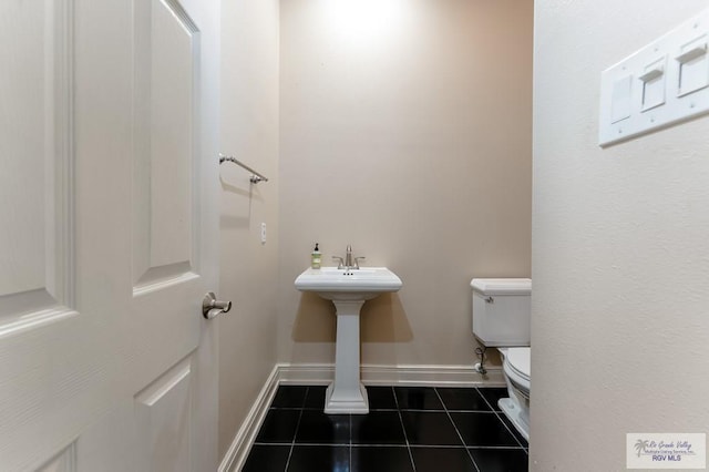 bathroom with toilet and tile patterned floors