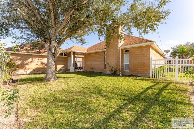 405 E Matz Ave, Harlingen, TX 78550 - view of front of house with concrete block siding, a chimney, and a shingled roof