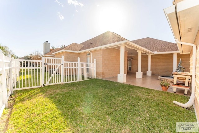 rear view of house with a lawn and a patio