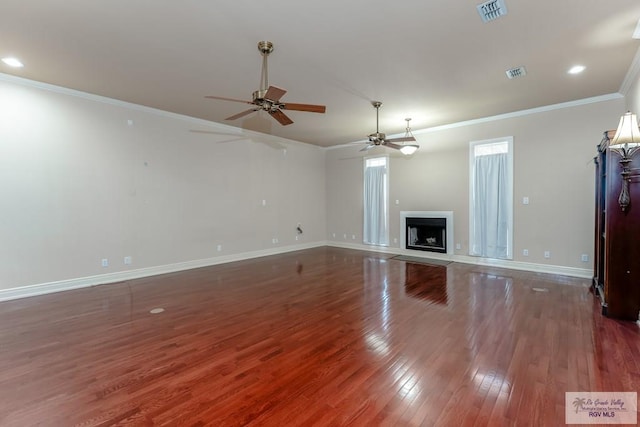 unfurnished living room with ceiling fan, dark wood-type flooring, and ornamental molding