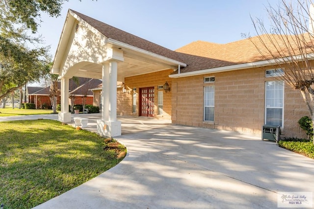 405 E Matz Ave, Harlingen, TX 78550 - view of front facade featuring a shingled roof, a front lawn, and concrete block siding