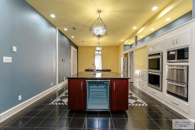 kitchen with stainless steel appliances, a notable chandelier, white cabinets, wine cooler, and hanging light fixtures