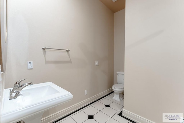 bathroom with tile patterned flooring, toilet, and sink