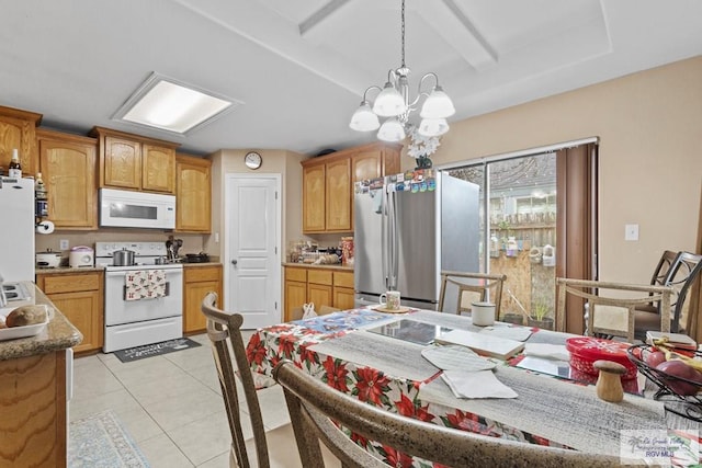 kitchen with pendant lighting, a notable chandelier, white appliances, and light tile patterned floors