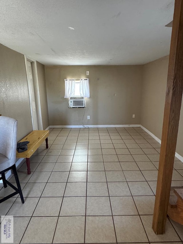 spare room with light tile patterned floors, a textured ceiling, and cooling unit