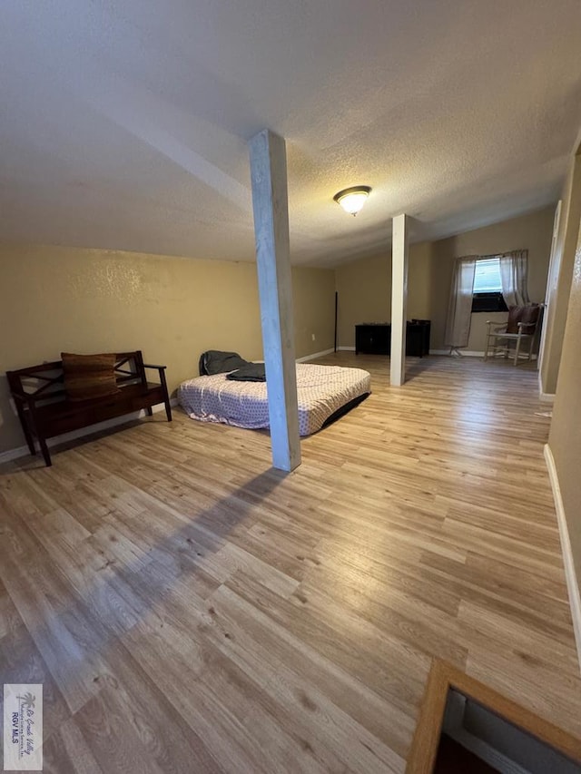 bedroom with a textured ceiling and light hardwood / wood-style floors