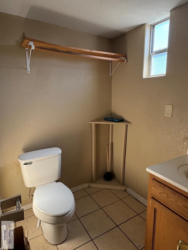 bathroom featuring toilet, a textured ceiling, vanity, and tile patterned floors