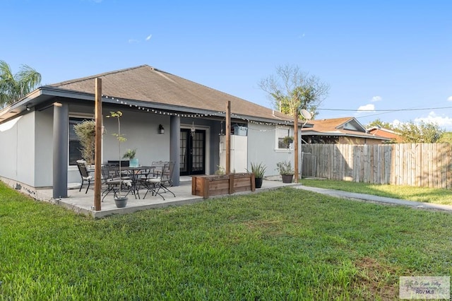 back of house with a patio area and a lawn