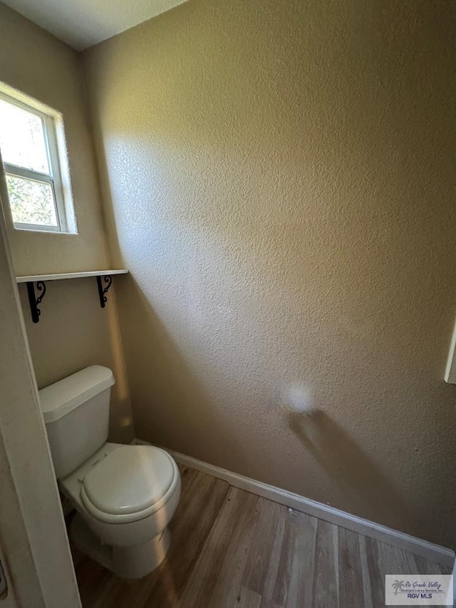 bathroom featuring hardwood / wood-style floors and toilet