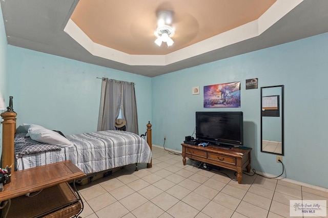 bedroom featuring a raised ceiling, ceiling fan, and light tile patterned floors