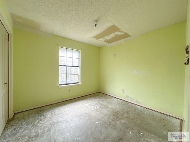 unfurnished bedroom with unfinished concrete floors, a closet, and a textured ceiling