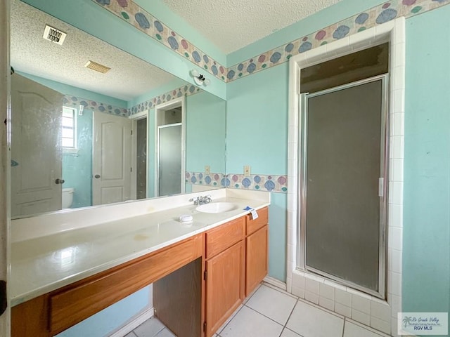 bathroom featuring visible vents, a textured ceiling, a stall shower, and vanity