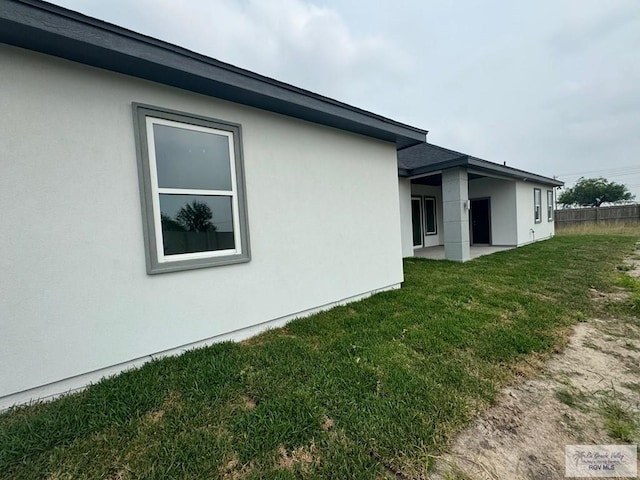 view of property exterior with a yard and stucco siding