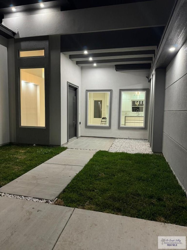 doorway to property with a lawn