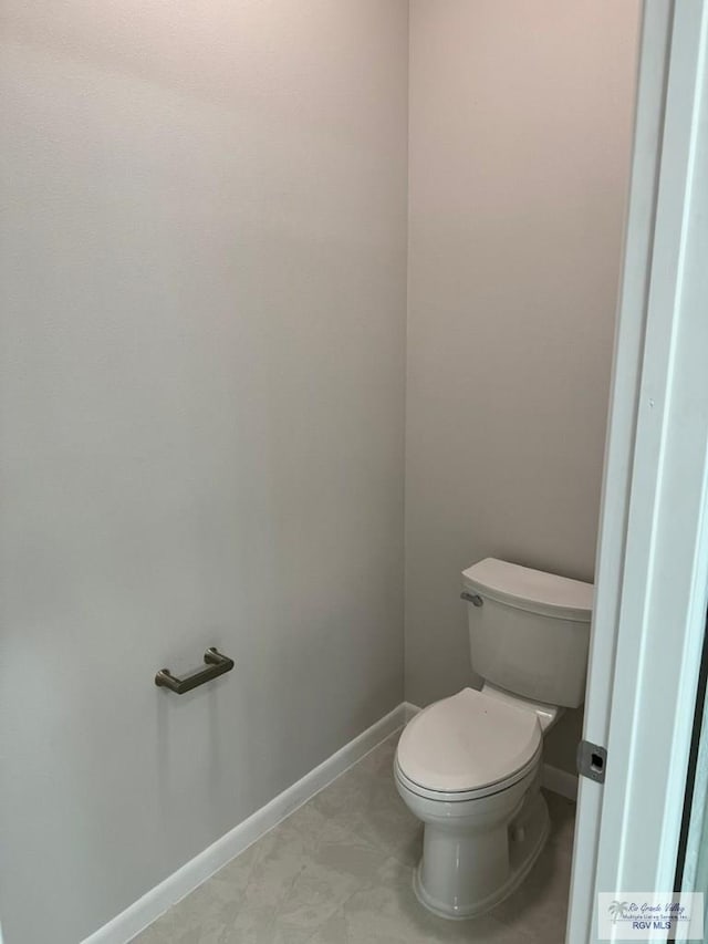 bathroom featuring toilet and baseboards