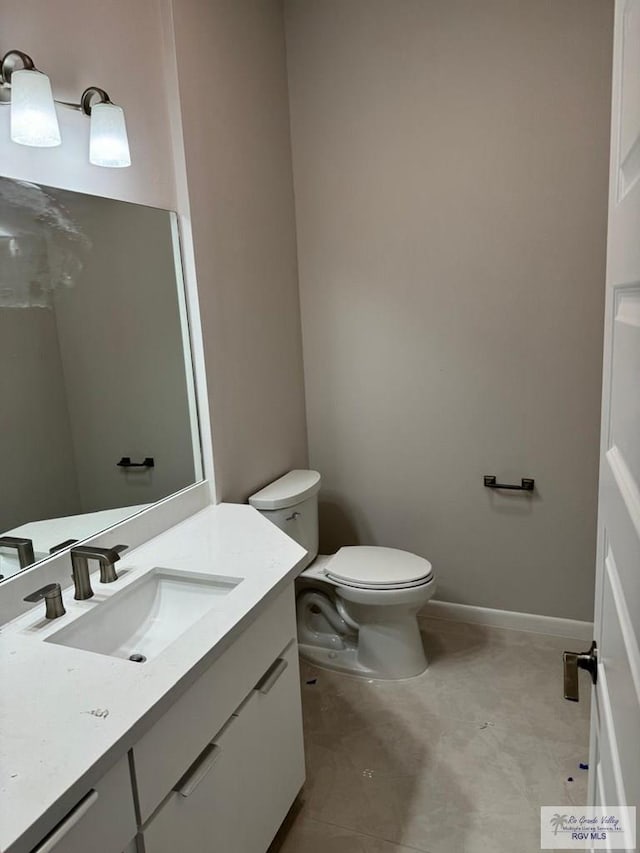 bathroom featuring vanity, baseboards, and toilet