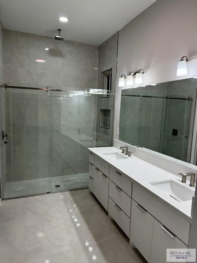 bathroom with double vanity, a sink, and a stall shower