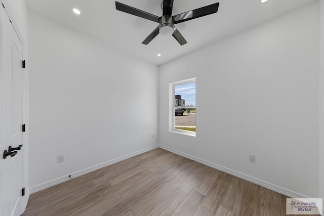 empty room with ceiling fan and light hardwood / wood-style flooring