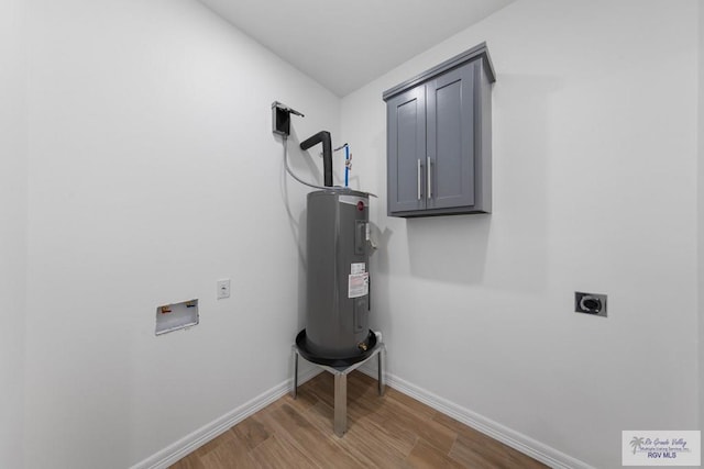 laundry area with cabinets, hookup for an electric dryer, water heater, hookup for a washing machine, and hardwood / wood-style flooring