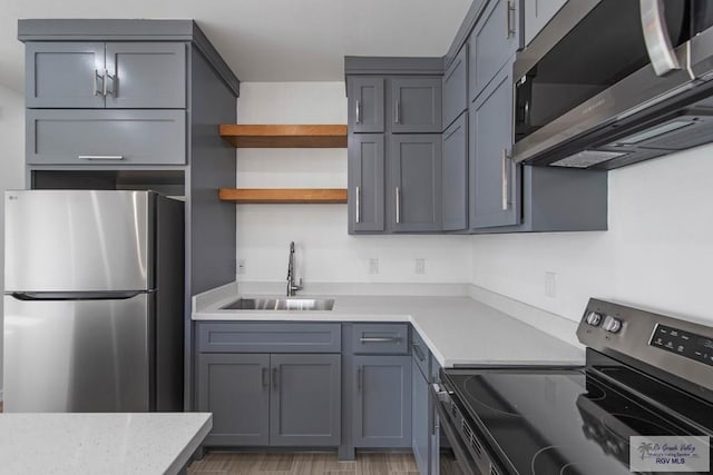 kitchen with stainless steel appliances, gray cabinets, and sink