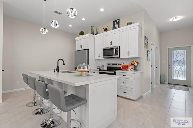 213B W Cora Lee Dr Unit B, South Padre Island, TX 78597 - kitchen with stainless steel appliances, a kitchen breakfast bar, light countertops, a center island with sink, and white cabinets