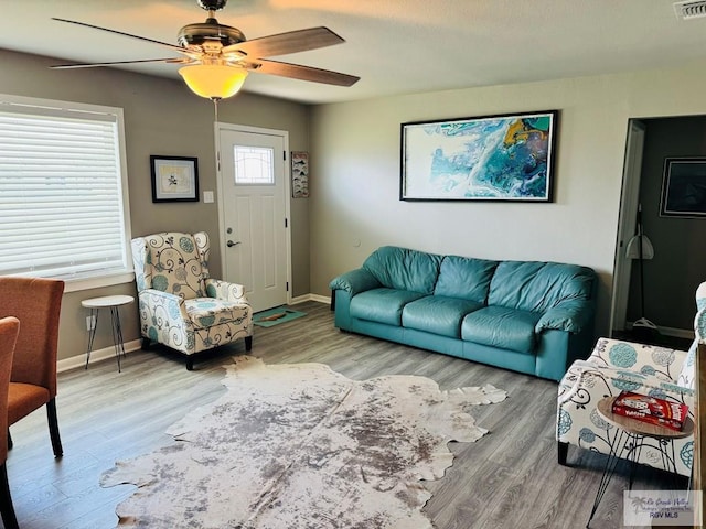 living room featuring ceiling fan and hardwood / wood-style floors