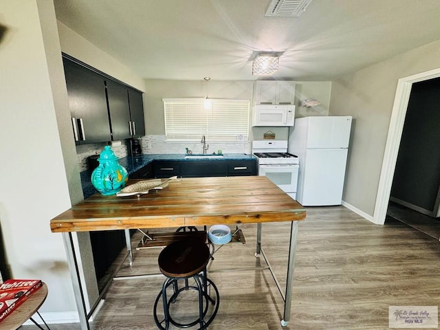 kitchen featuring sink, light hardwood / wood-style floors, and white appliances