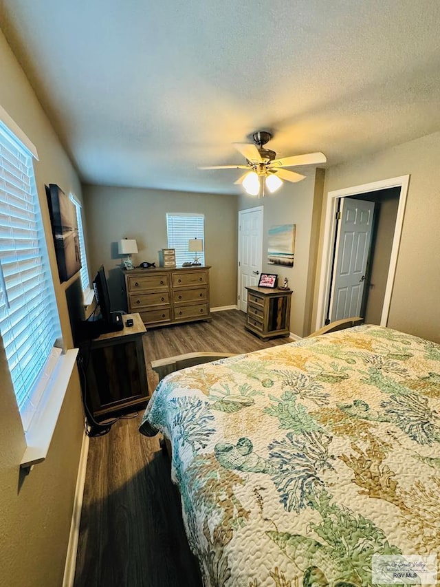 bedroom with ceiling fan, wood-type flooring, and a textured ceiling