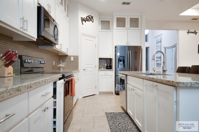 kitchen featuring white cabinets, stainless steel appliances, and sink