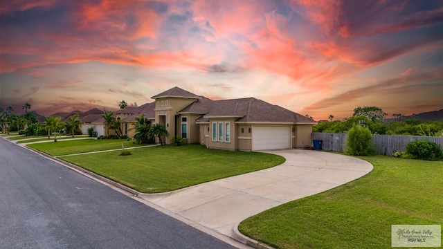 prairie-style house featuring a garage and a yard