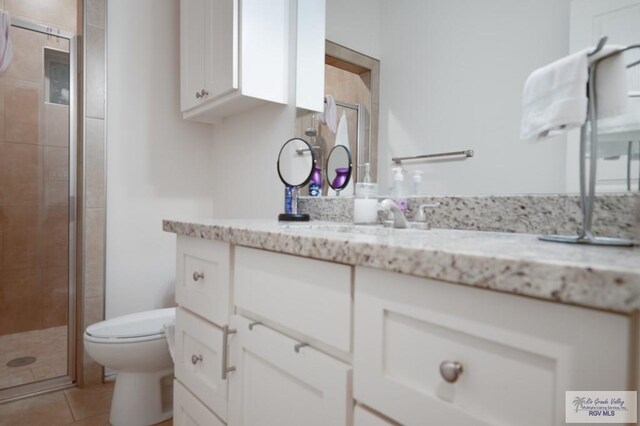 bathroom with walk in shower, tile patterned flooring, vanity, and toilet