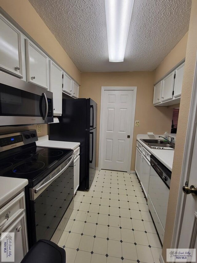 kitchen with sink, white cabinets, stainless steel appliances, and a textured ceiling