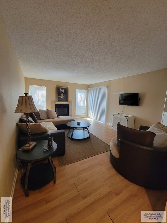 living room with wood-type flooring and a textured ceiling