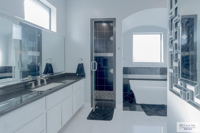 bathroom with plenty of natural light, vanity, and plus walk in shower