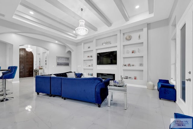 living room featuring built in shelves, beam ceiling, a tray ceiling, and an inviting chandelier