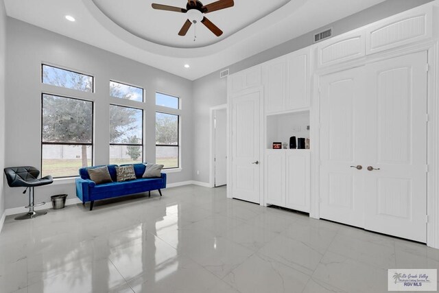 bedroom featuring ceiling fan and a tray ceiling