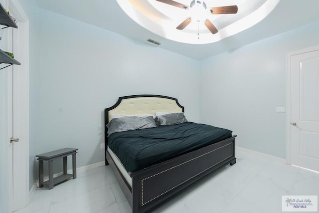 bedroom with a raised ceiling and ceiling fan