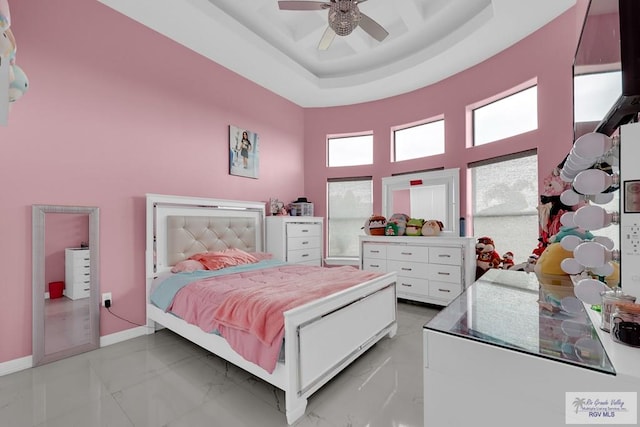 bedroom featuring a towering ceiling, a raised ceiling, and ceiling fan